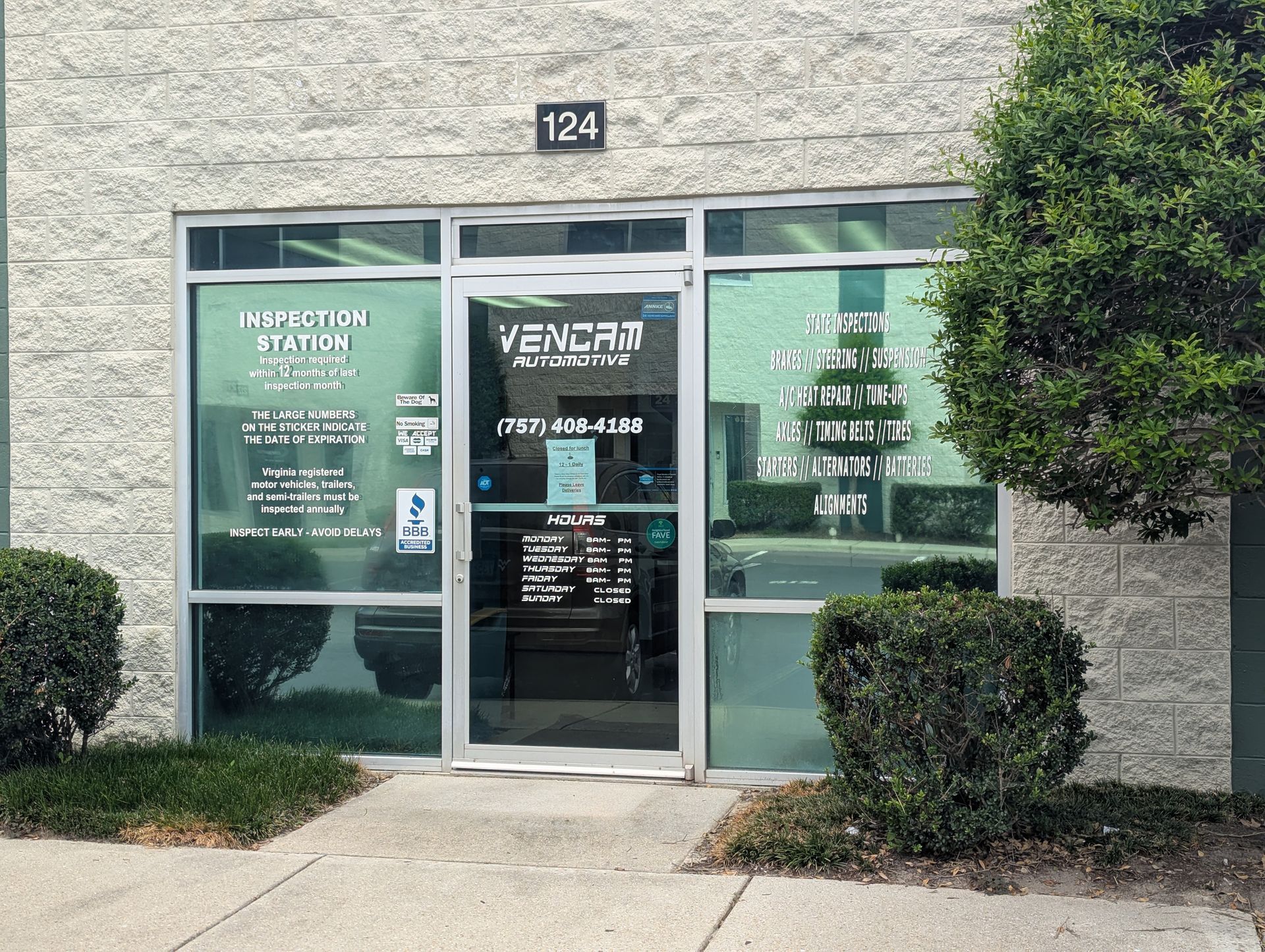 Red sports car raised on a lift in a garage, hood open. Other vehicles and equipment are visible. | Vencam Auto Repair