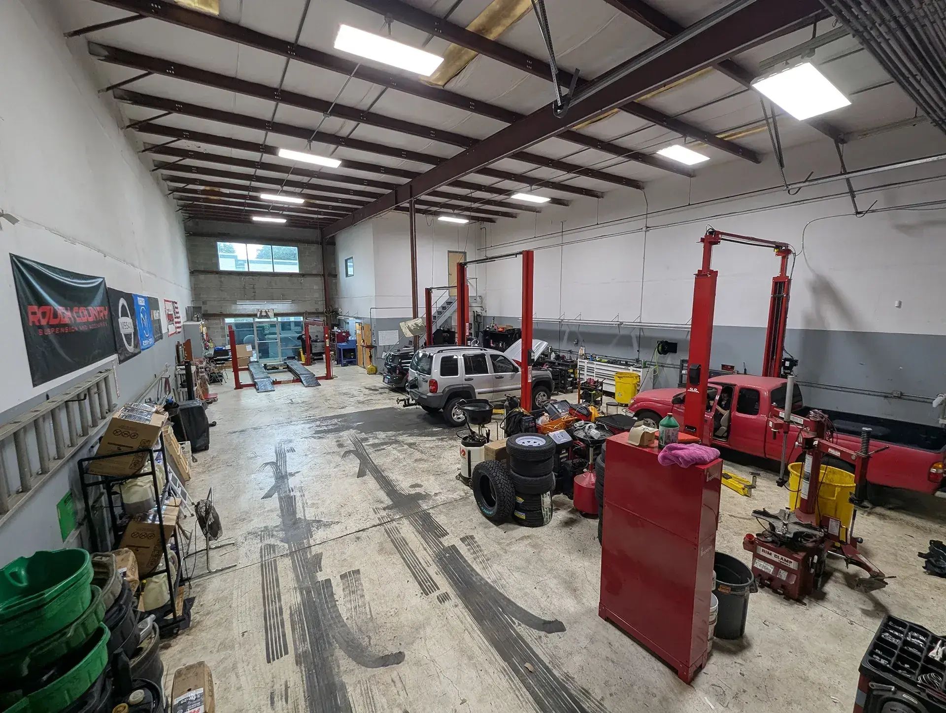 Interior of a repair shop with vehicles, lifts, tools, and a red toolbox | Vencam Auto Repair