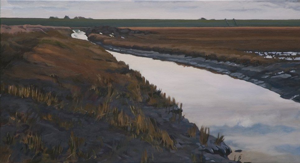 Een getijdenkreek snijdt door het wadland onder een uitgestrekte, zacht verlichte hemel die weerspiegelt in de kalme vaart.