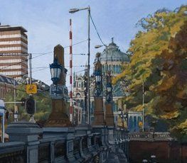 Een brug met sierlijke lantaarns op de voorgrond, met een groot koepelvormig gebouw en herfstbomen op de achtergrond.