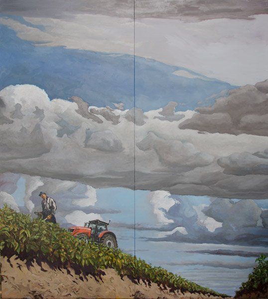 Een boer staat in een veld naast een tractor onder een dramatische, bewolkte hemel.