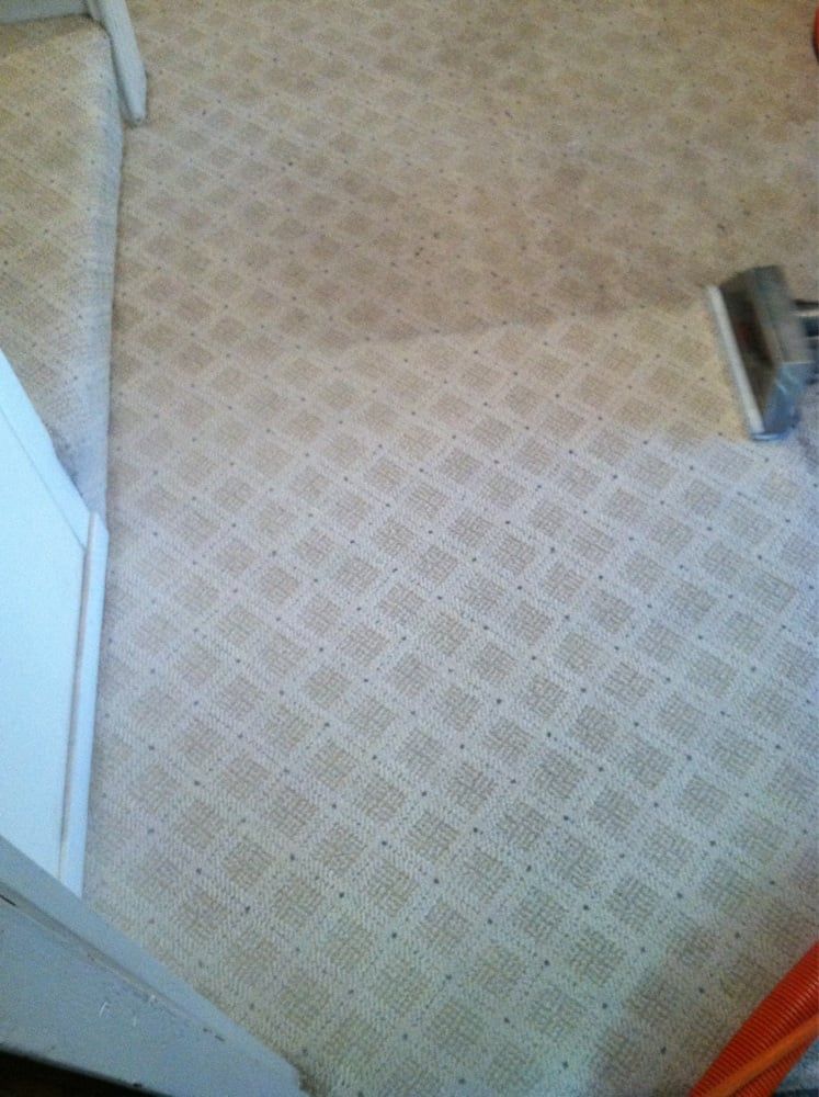 Carpeted floor with a geometric pattern, a white wall edge, and a small metal fixture on the right