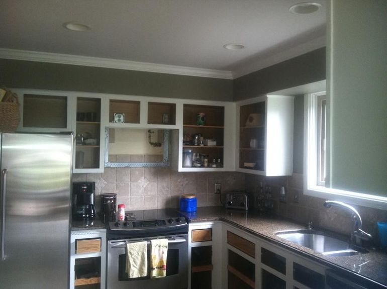 A kitchen with stainless steel appliances and white cabinets