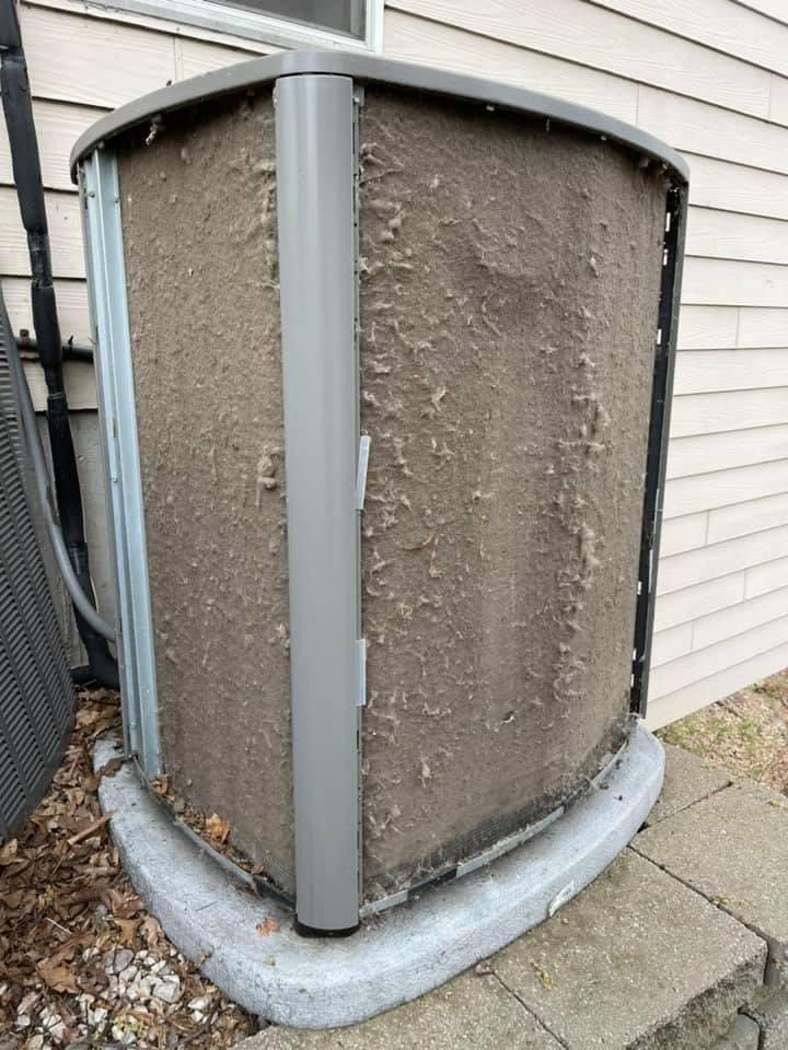 Exterior air conditioner with a heavily clogged coil, outdoors.