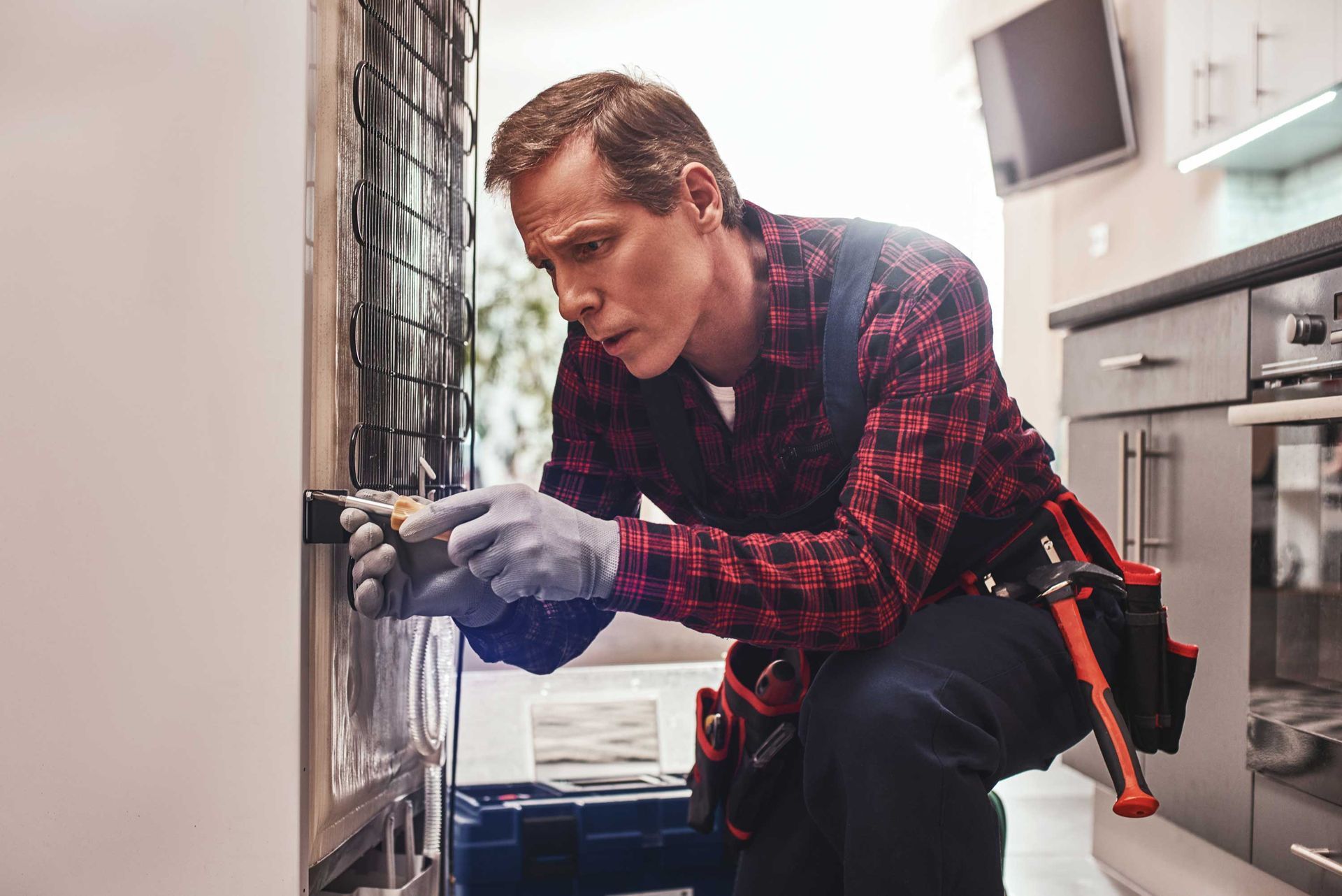 Senior male technician checking refrigerator.