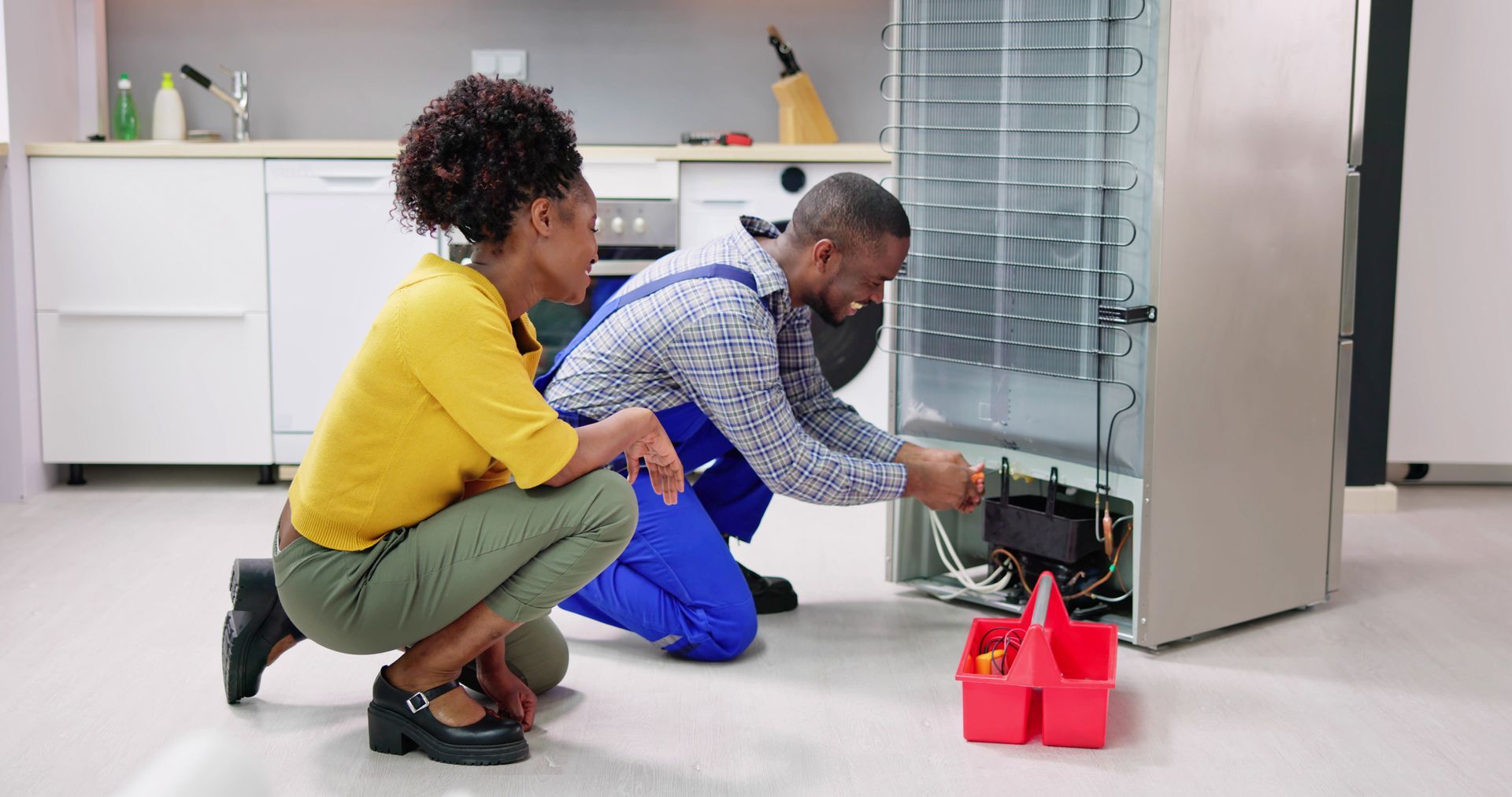 Damaged fridge being fixed by a professional appliance repair expert. Damaged fridge being fixed by a professional appliance repair expert.