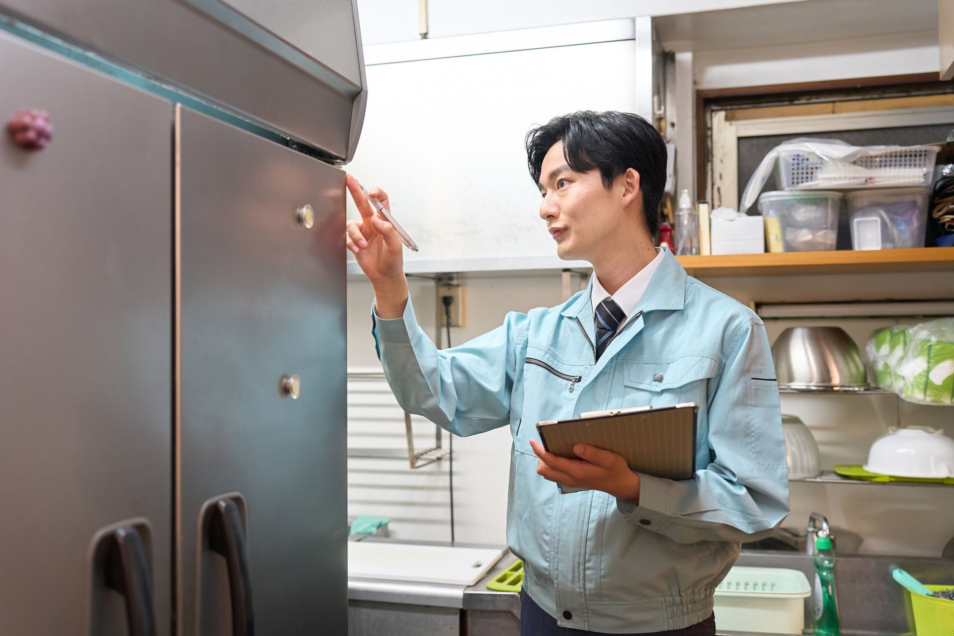 A man checking a restaurant's refrigerator. A man checking a restaurant's refrigerator.