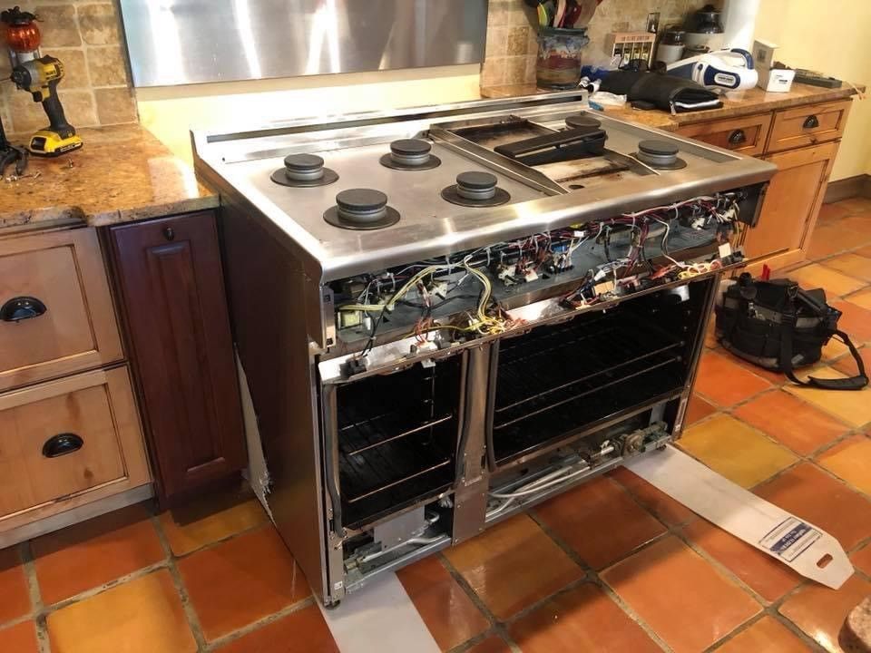Stainless steel oven in a kitchen being repaired.