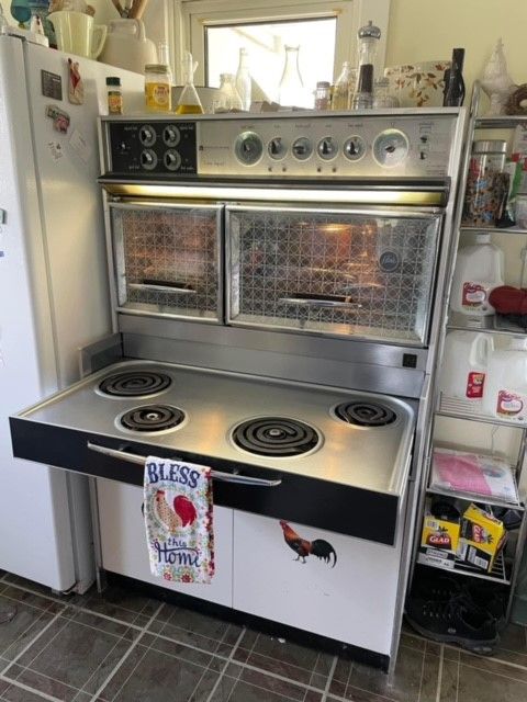 Vintage electric oven with cooktop, two ovens, and rooster design, in a kitchen.