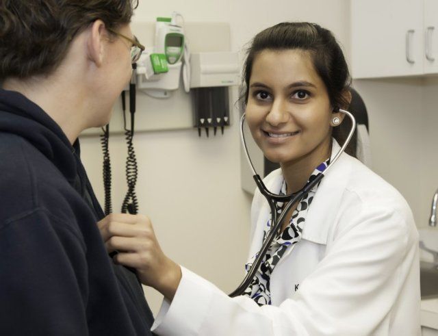 A female doctor examines a patient with a stethoscope