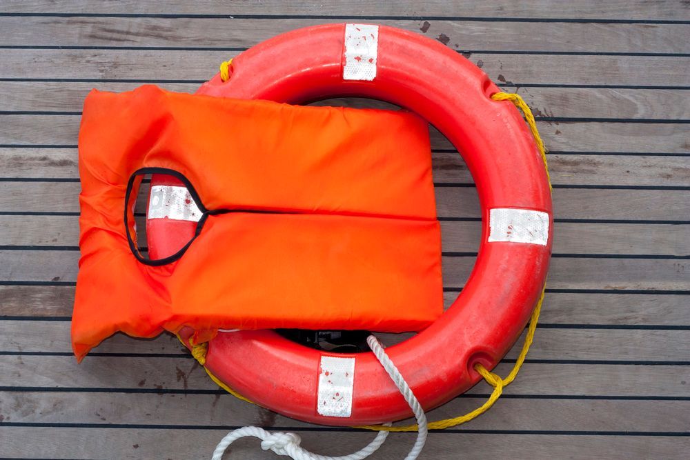 Un salvavidas está sentado sobre una cubierta de madera.