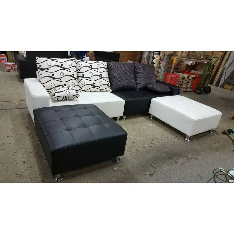 A black and white sectional couch with ottomans and pillows