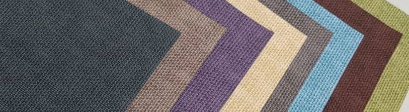 A bunch of different colored fabrics are stacked on top of each other.