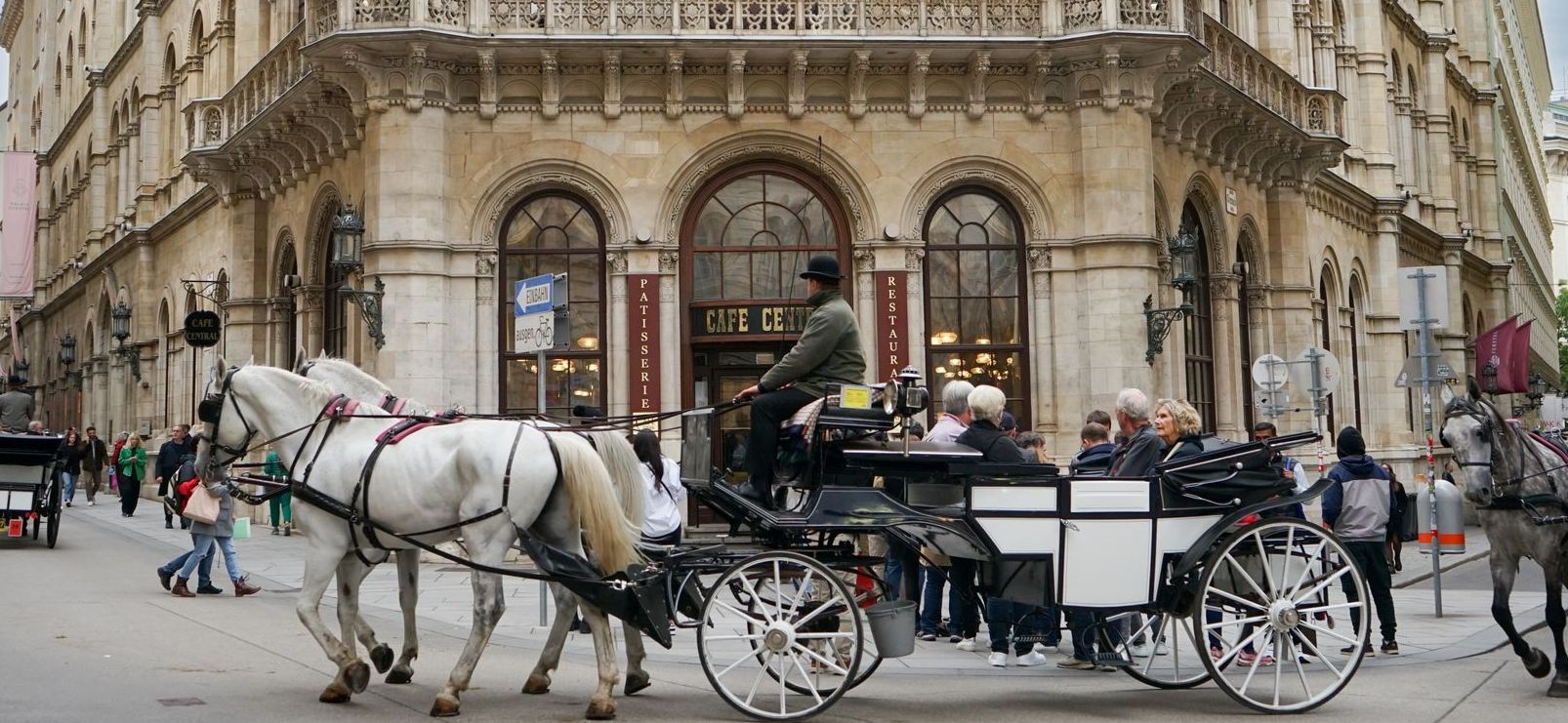 Traditional Fiaker carriage ride passing by the Vienna State Opera in Vienna