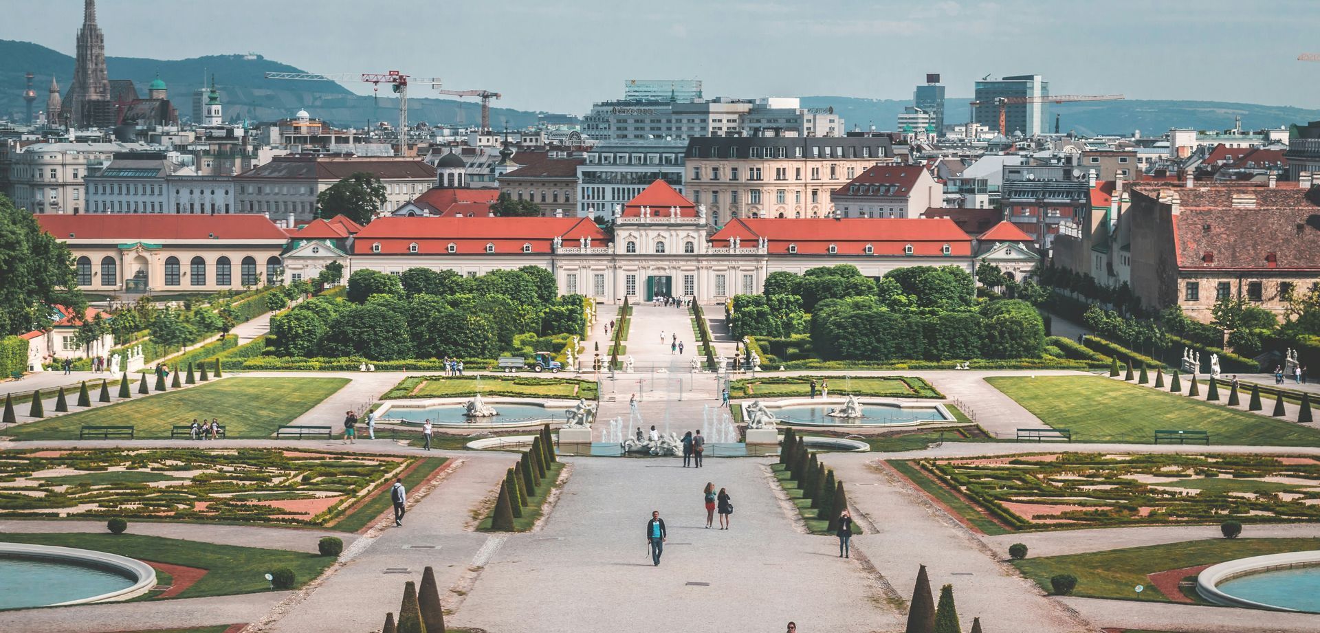 Belvedere Gardens – A Baroque Oasis in the Heart of Vienna A panoramic view of the formal Baroque gardens at Belvedere Palace in Vienna, with symmetrical paths, fountains, and city skyline in the background.
