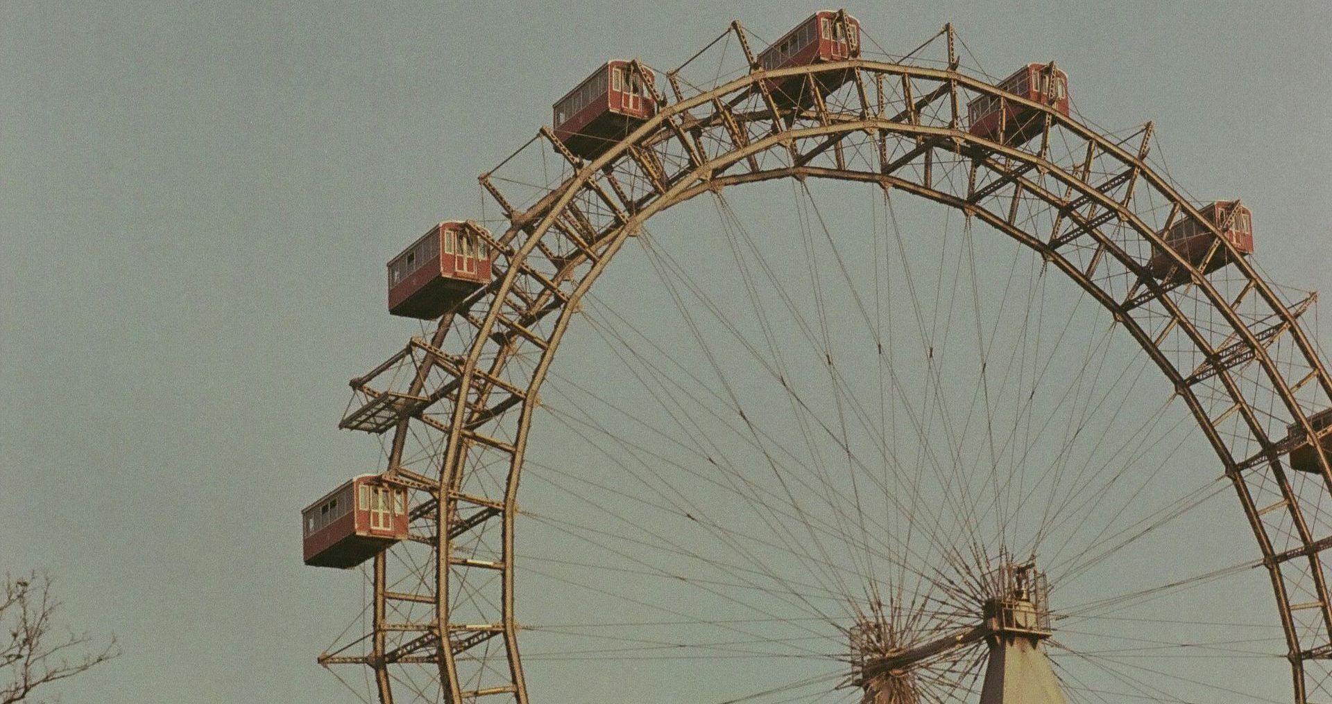 Wiener Riesenrad – Vienna’s Iconic Giant Ferris Wheel Close-up of the historic Giant Ferris Wheel in Vienna’s Prater amusement park on a cloudy day, with visible passenger cabins.