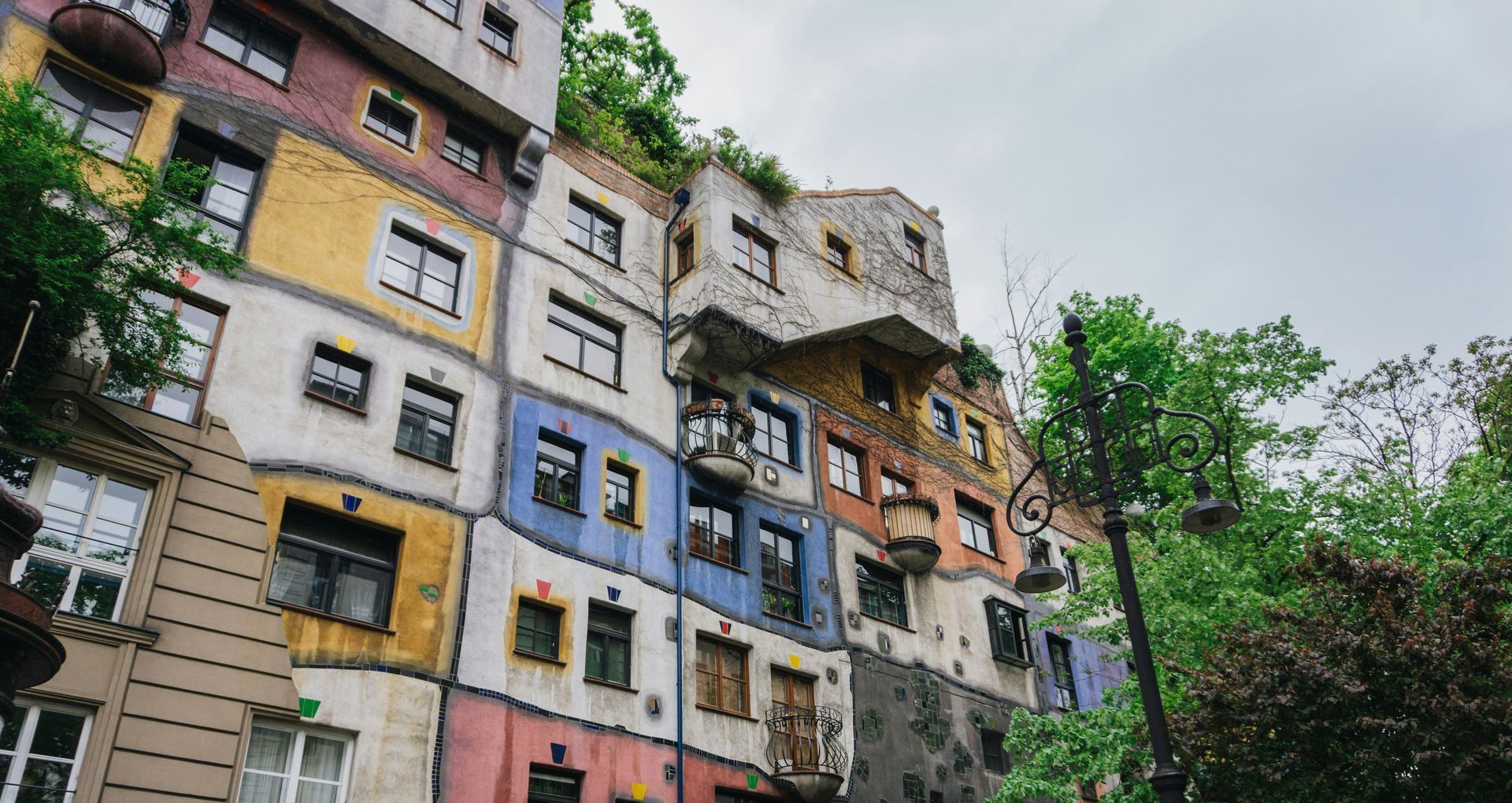 Hundertwasserhaus – Vienna’s Most Colorful Apartment Building Colorful exterior of Hundertwasserhaus in Vienna, featuring irregular windows, curved lines, and rooftop greenery.