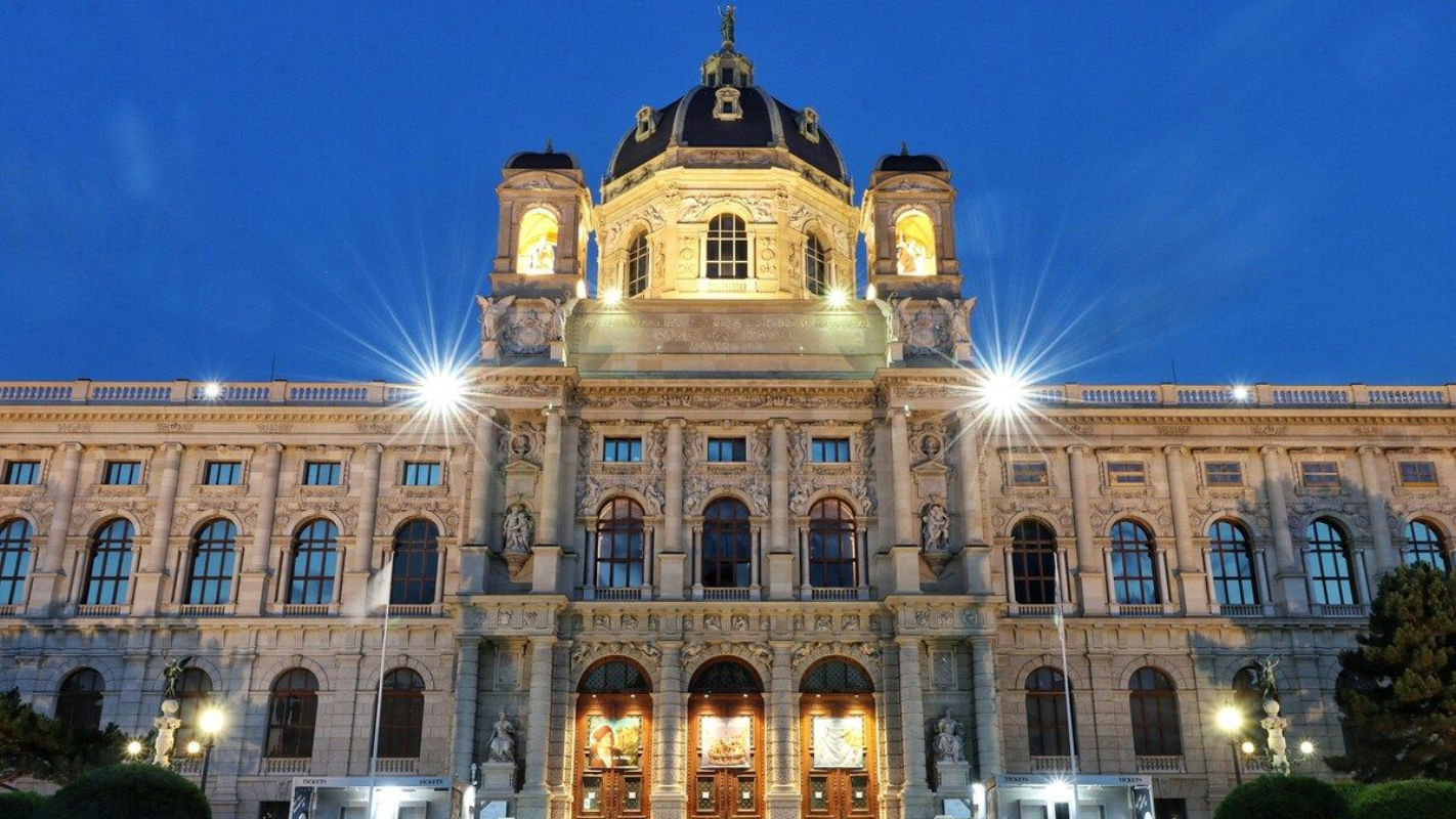Evening lights highlight the grand facade of the Kunsthistorisches Museum in Vienna Front view of the Kunsthistorisches Museum in Vienna lit up against the evening sky