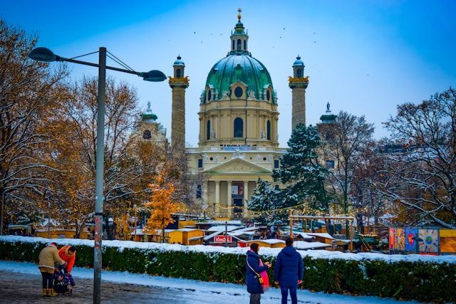 Vienna in December at Karlskirche (Karlsplatz): snow-covered church, Christmas market stalls