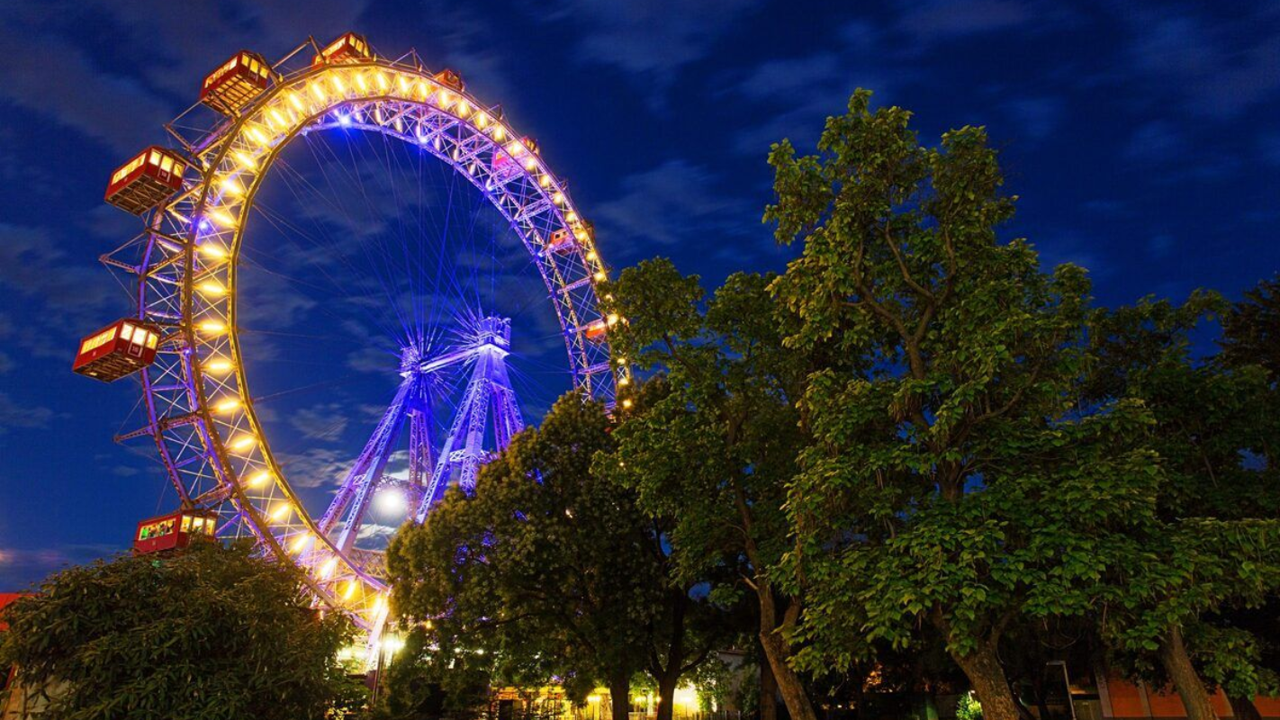 The Riesenrad Ferris Wheel against a deep blue night sky Giant Ferris Wheel at Vienna’s Prater park lit with colorful lights at night