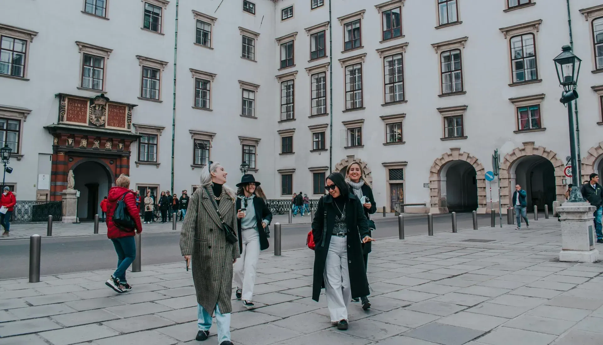 Visitors walking through Hofburg Palace courtyard in winter clothing—popular February sightseeing spot in central Vienna.