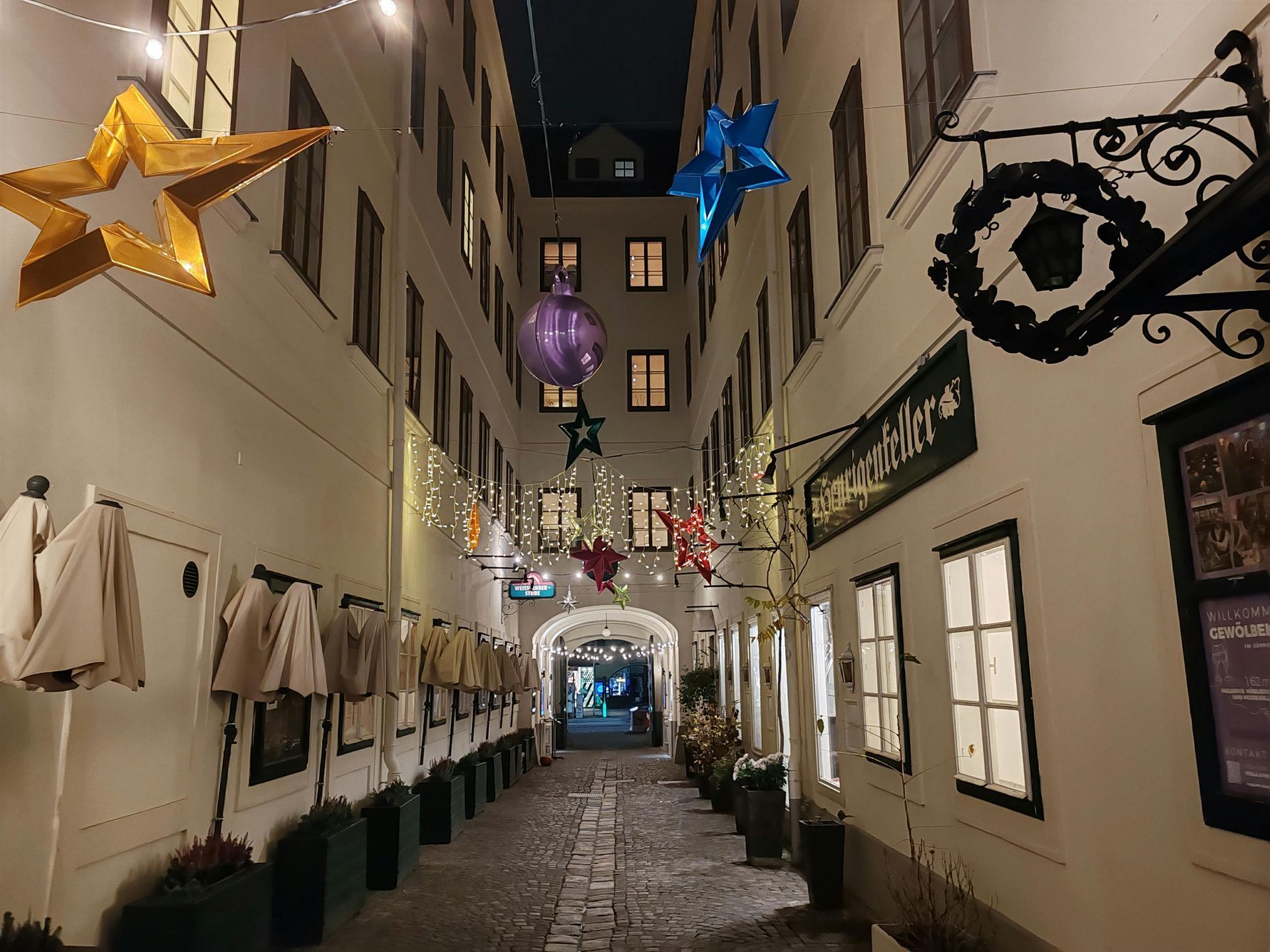 Winter evening in a decorated Vienna alley with hanging stars and cozy lights