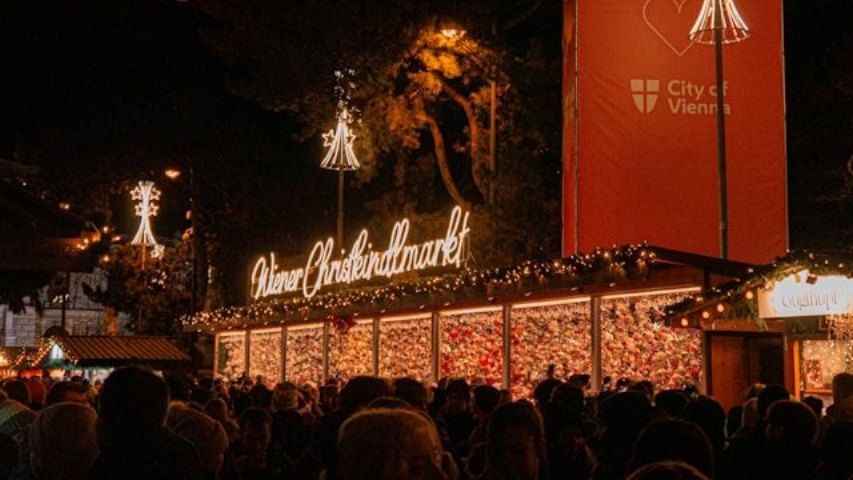 Vienna street in December with festive decorations and visitors drinking punch