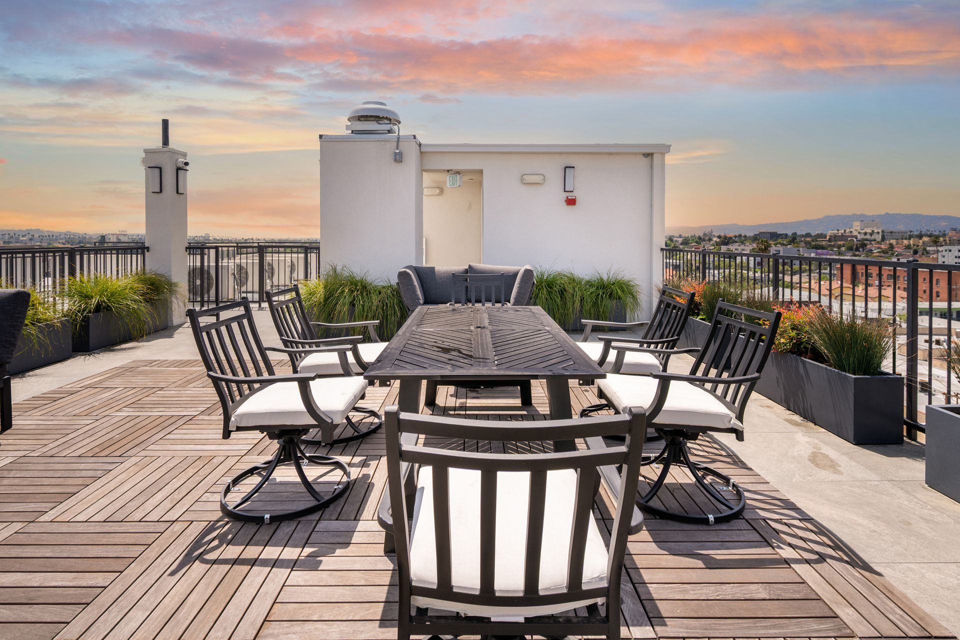 A rooftop deck with a table and chairs on it