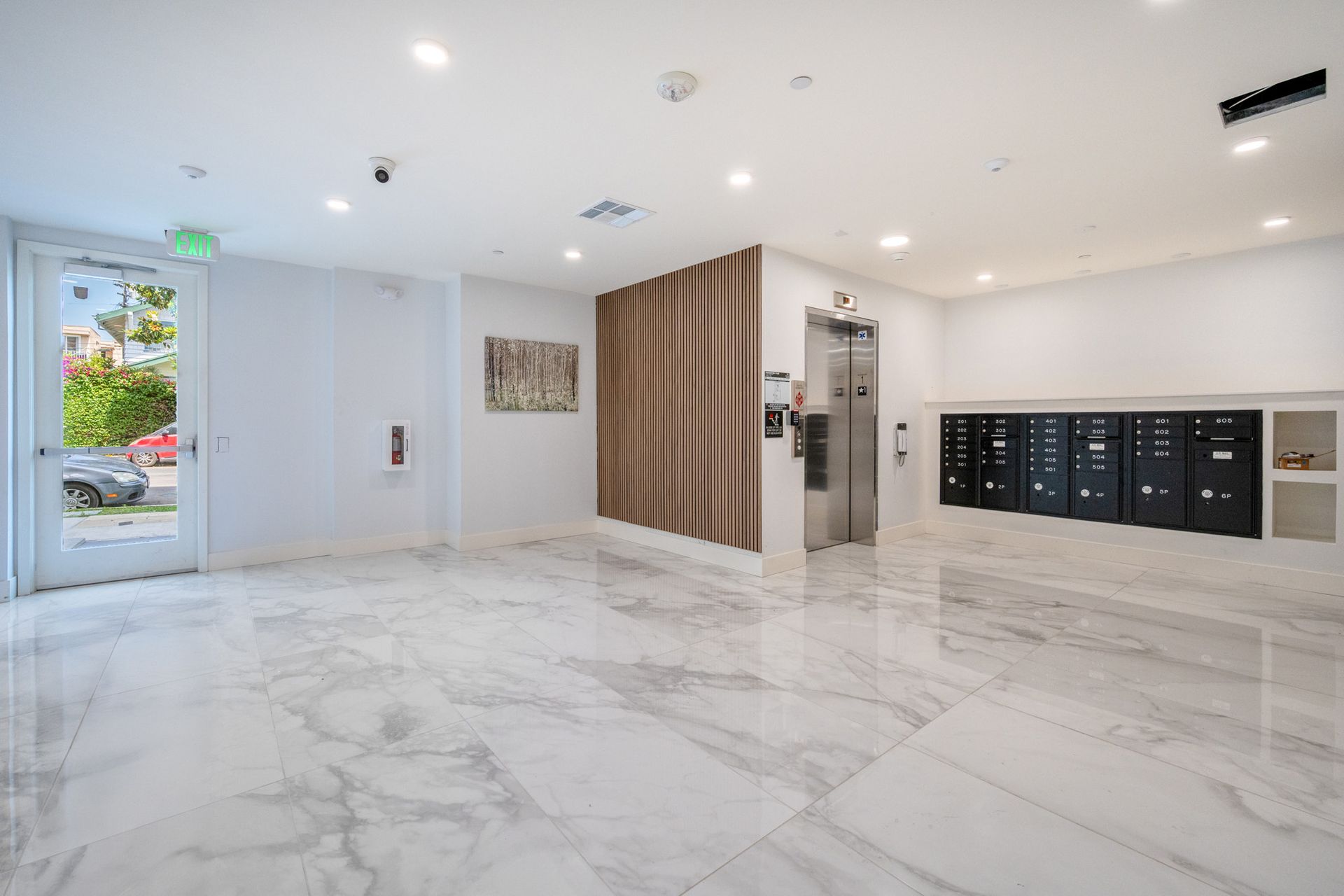A large empty room with a marble floor and elevator.