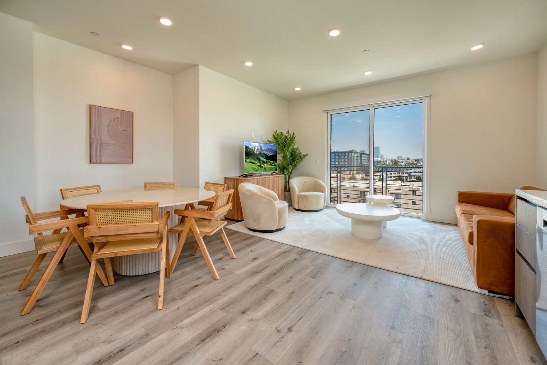 A living room with a table , chairs , a couch and a television.