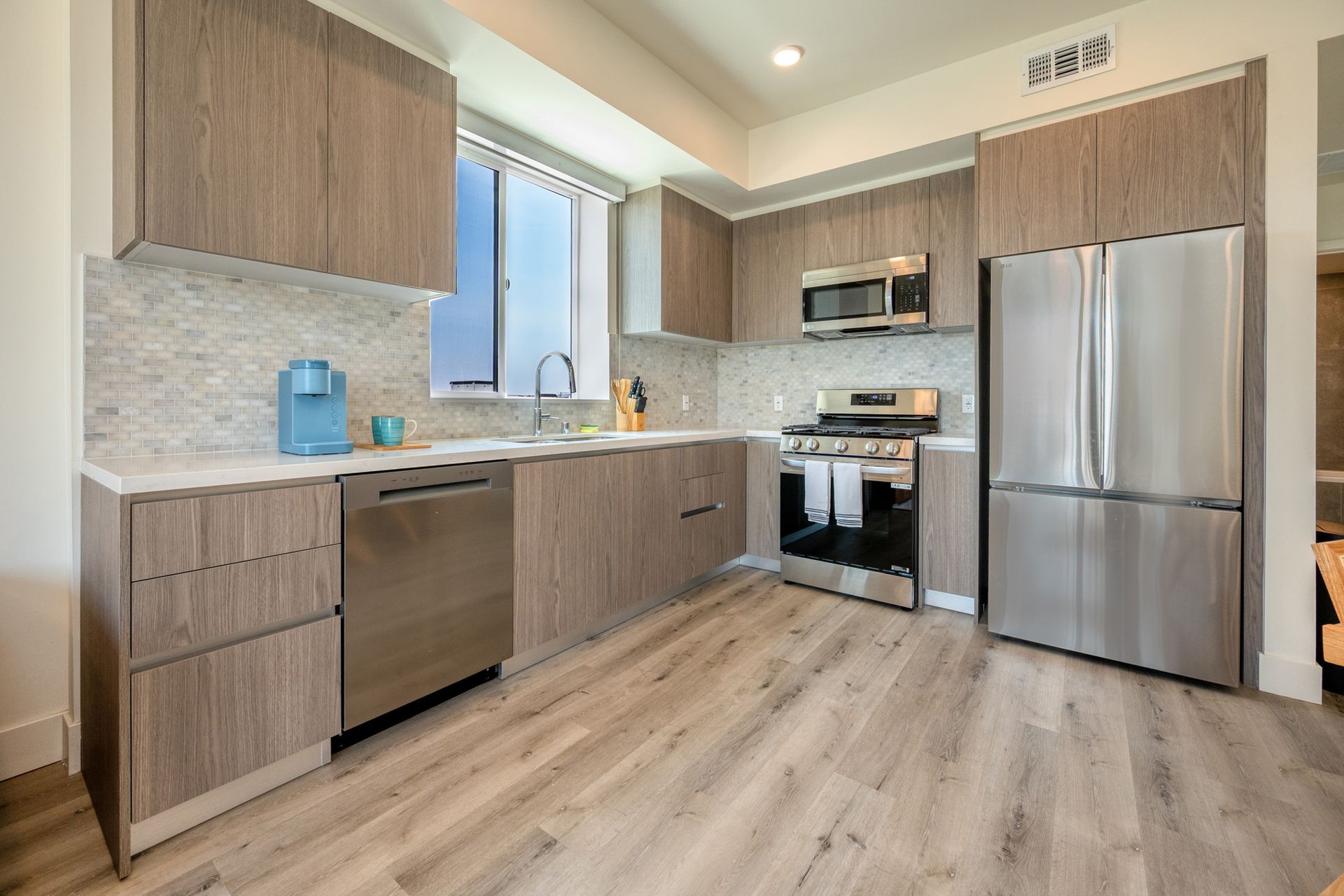 A kitchen with stainless steel appliances and wooden cabinets.
