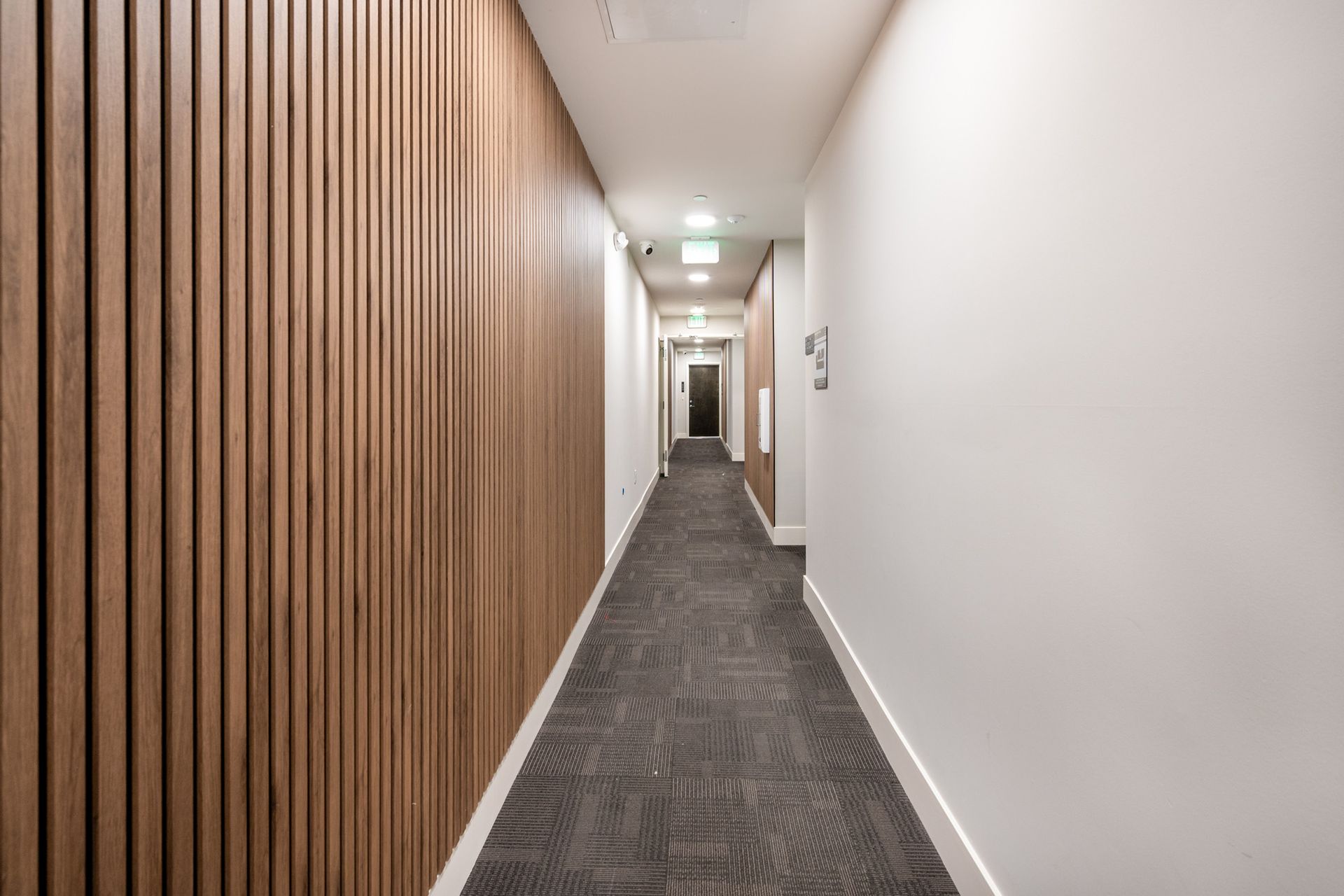 A long hallway with wooden walls and a carpeted floor.