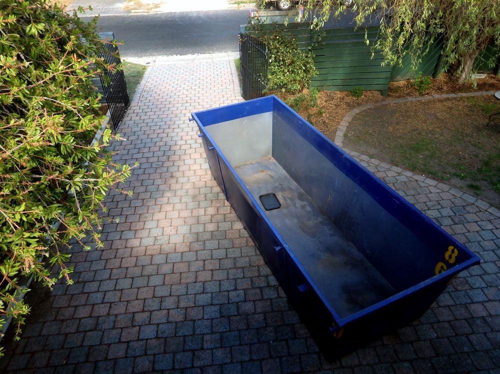 Blue Dumpster on a Brick Driveway, Next to Greenery and a Fence — Fat Boy Skips Townsville In Burdell, QLD