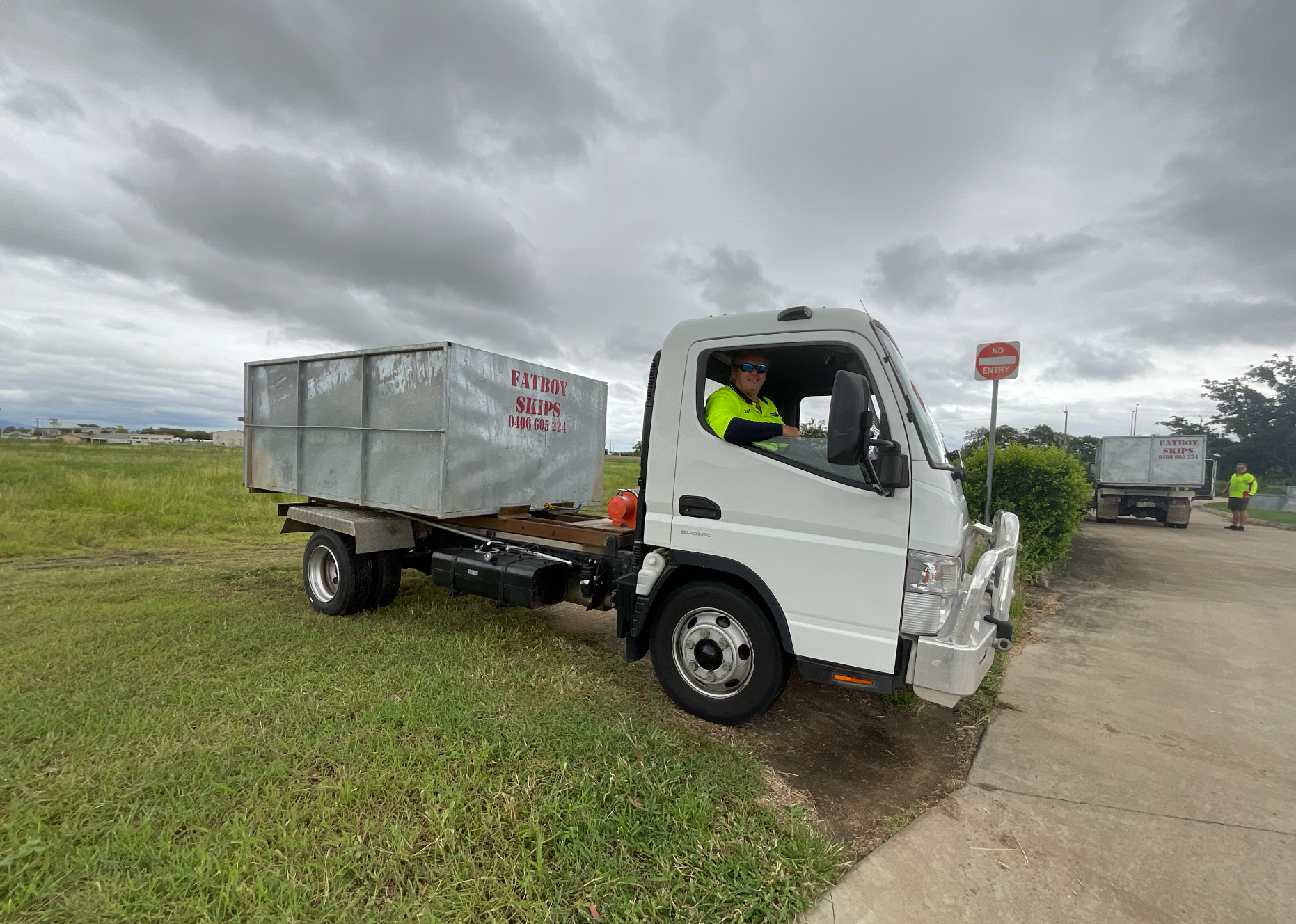 A Person Wearing Blue Gloves Is Putting A Plastic Cup Into A Blue Trash Bag — Fat Boy Skips Townsville In Nome, QLD