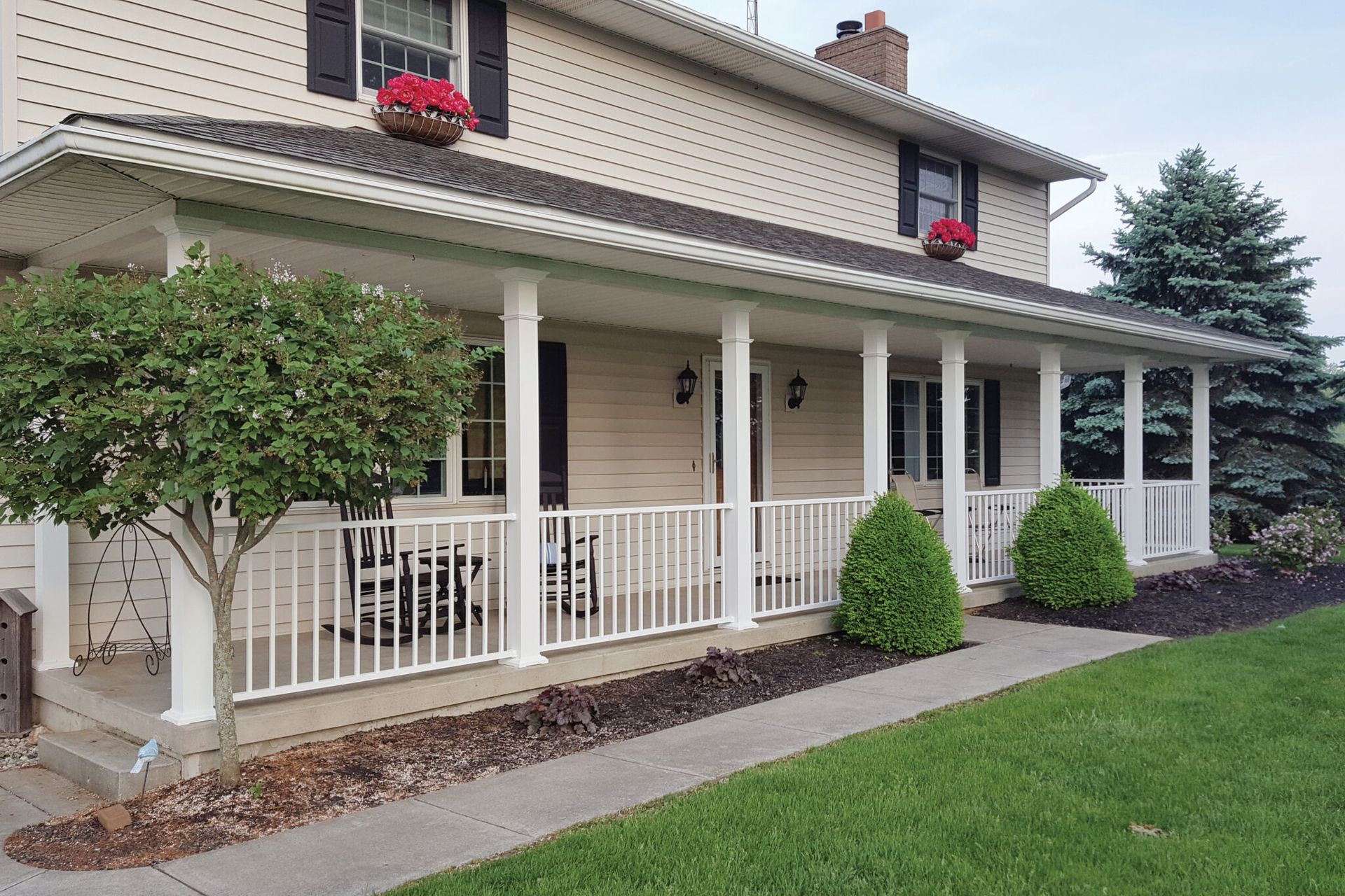 Person holding plumbing pipes and fittings in a dirt trench, near other pipes and a drain.