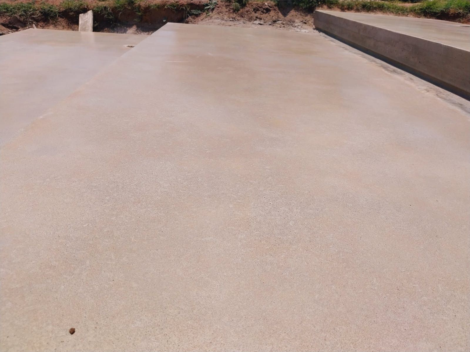 Losa de hormigón recién vertida, color marrón claro, superficie plana, obra en construcción.