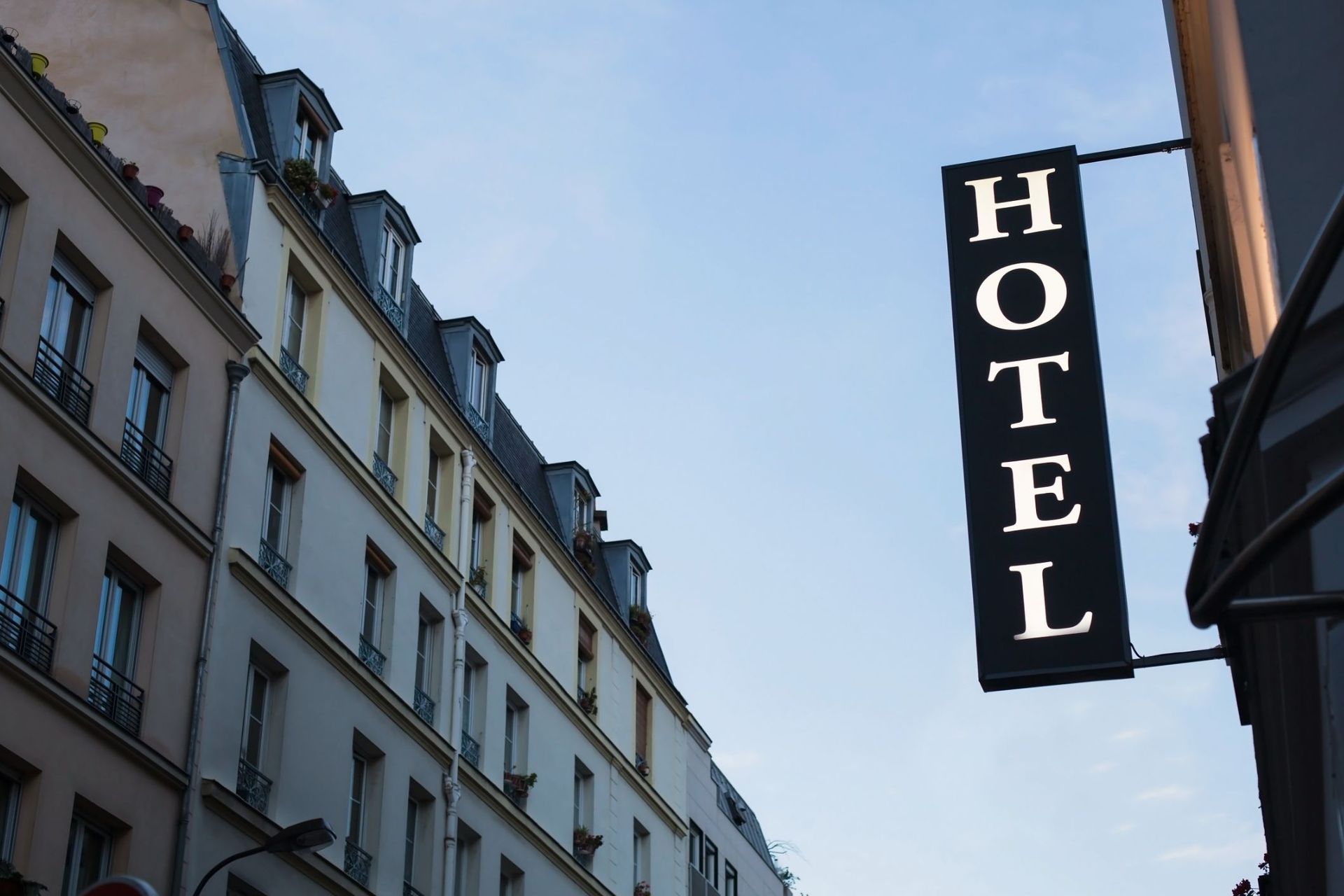 A hotel sign hangs on the side of a building