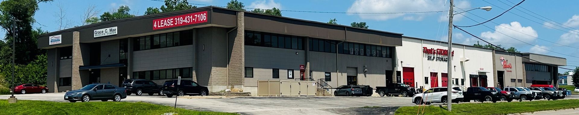 A large building with a lot of cars parked in front of it.