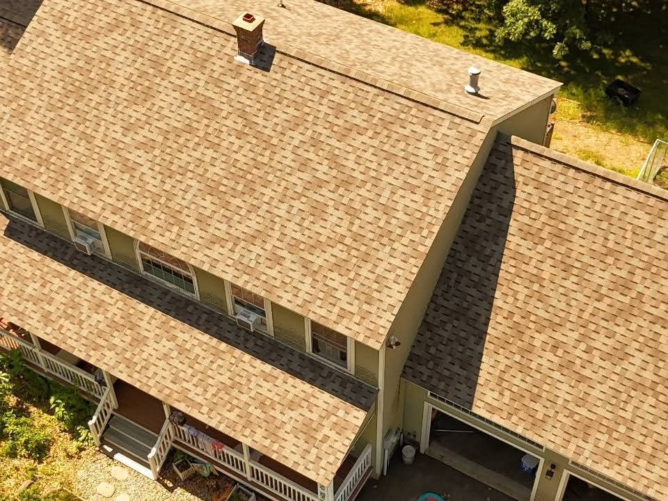 Black roof vent pipe on gray asphalt shingles with a square flashing base