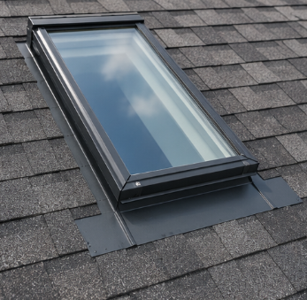 Black skylight window installed on a gray shingled roof