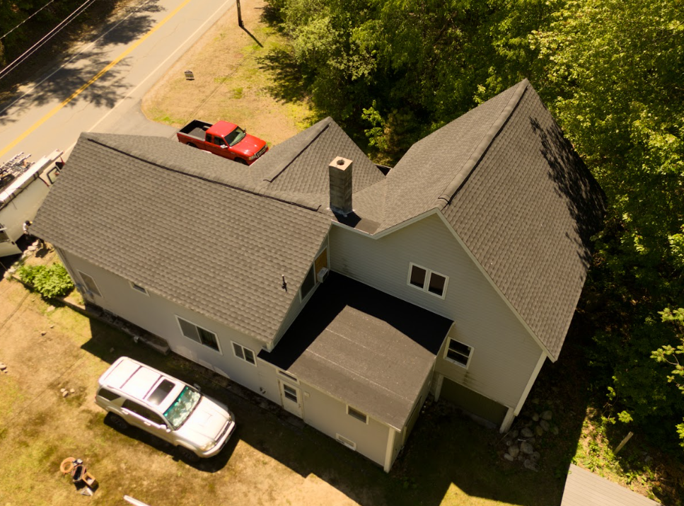 Black drone flying over a suburban house on a clear day