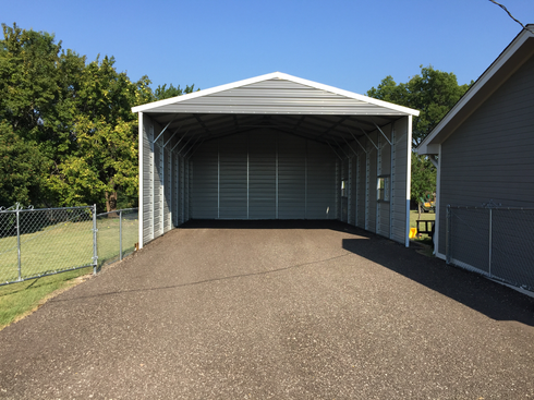 Freshly repaired gravel pad in front of a grey carport