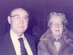 A black and white photo of an elderly woman wearing glasses.