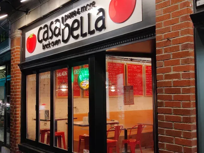 A restaurant with tables and chairs in front of a brick building.