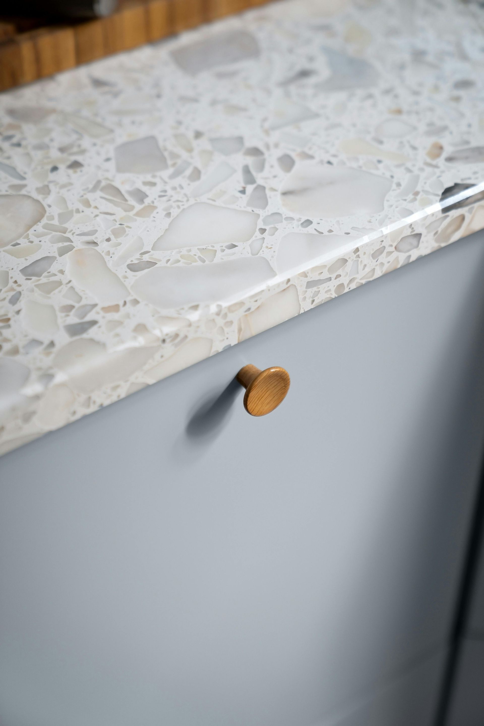 A close up of a kitchen counter with a brass knob on it.