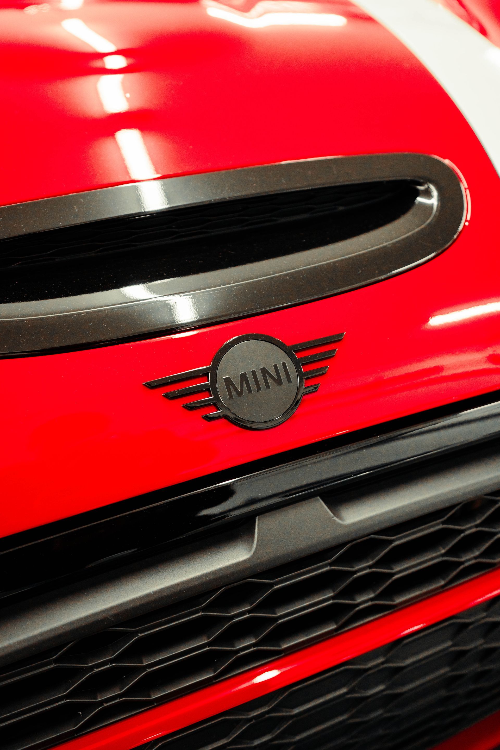 A close up of the front of a red mini cooper