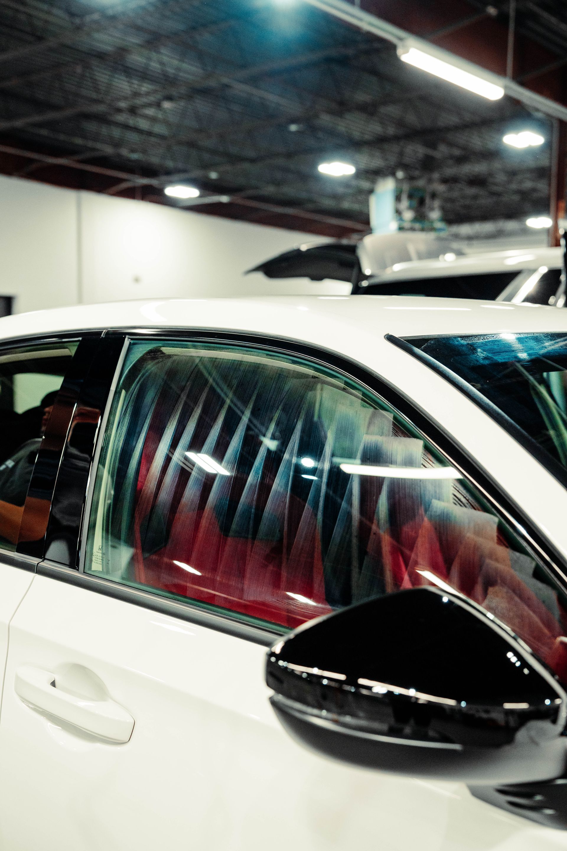 A white car with red seats is parked in a garage.