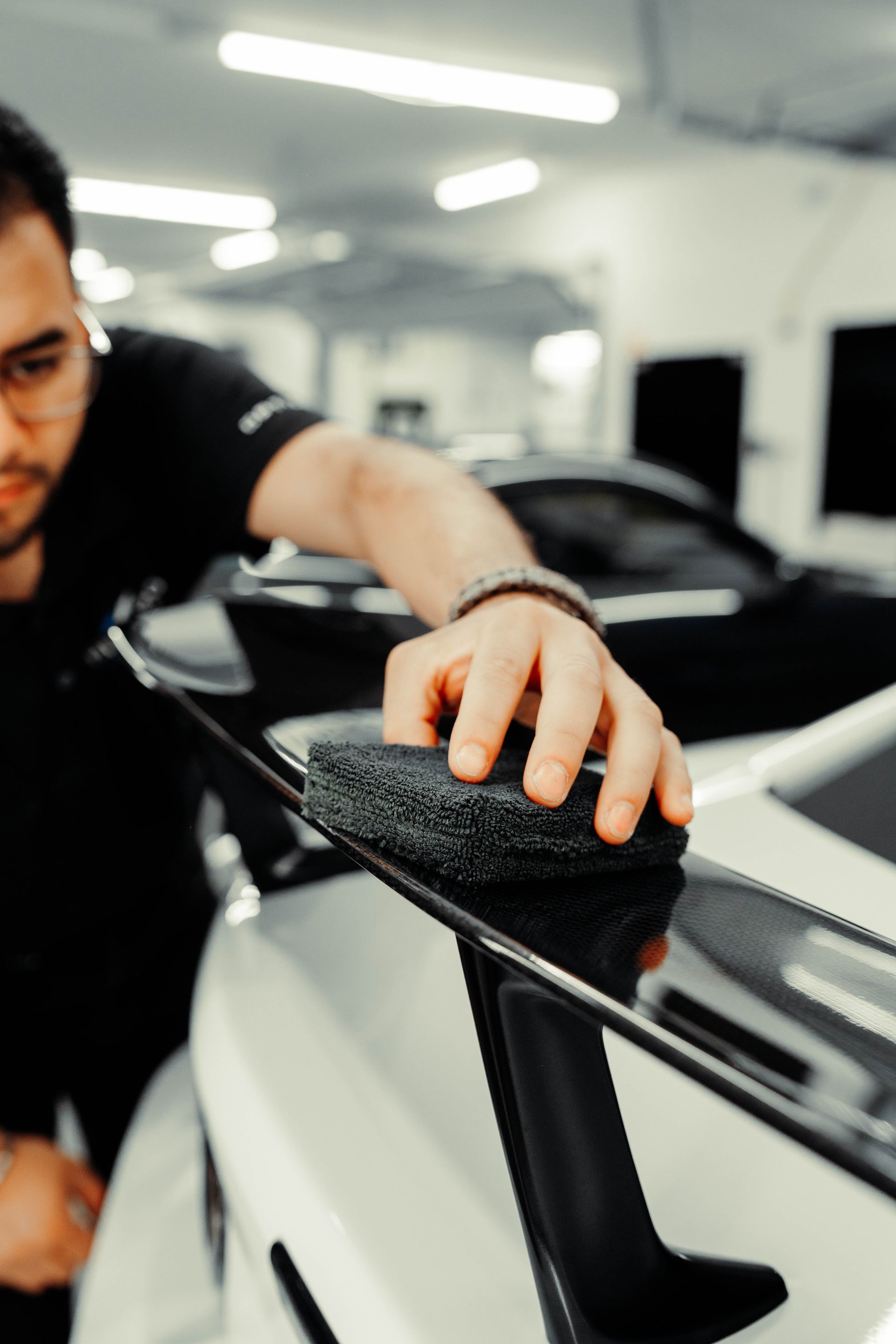 A man is polishing a car with a sponge.