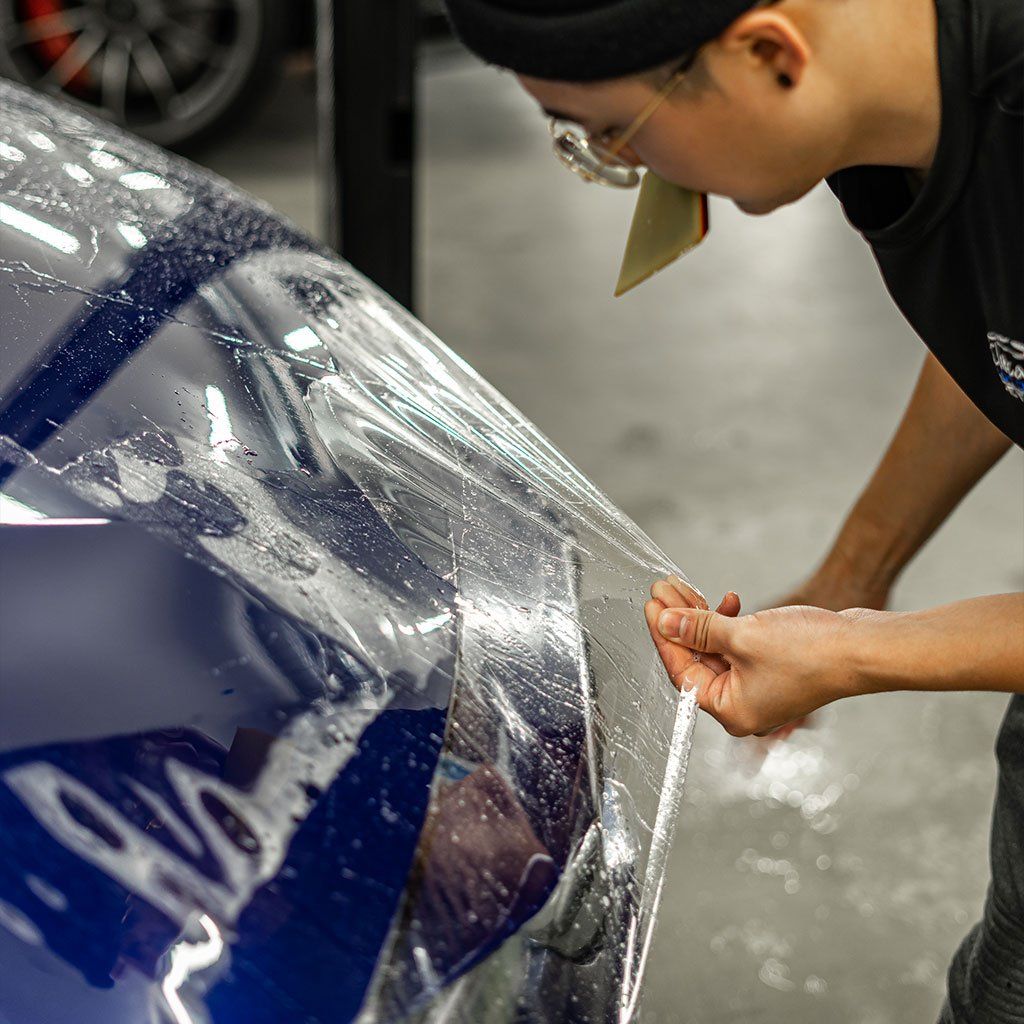 a red sports car is parked in a garage next to a black car .