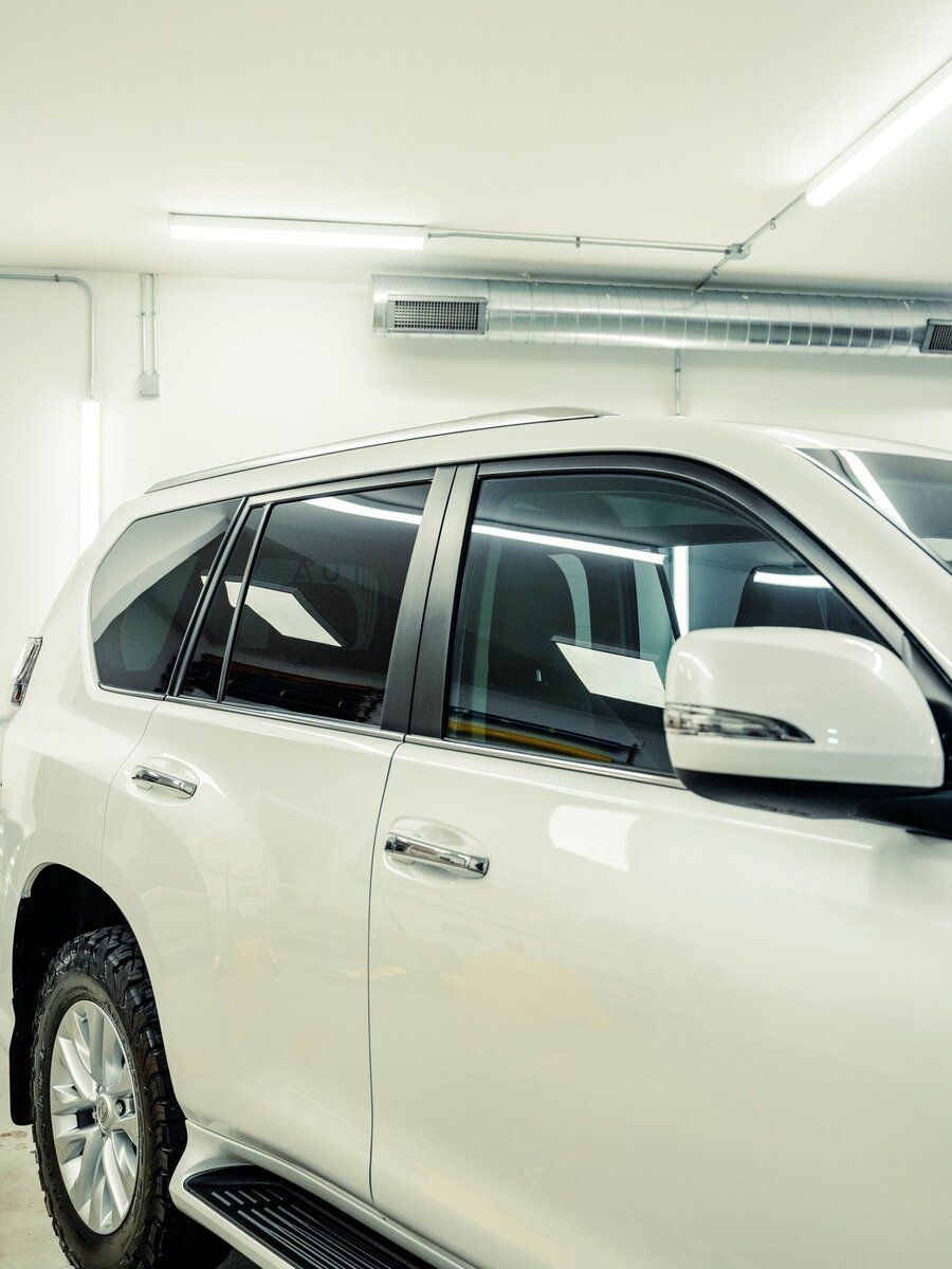 A white suv is parked in a garage.